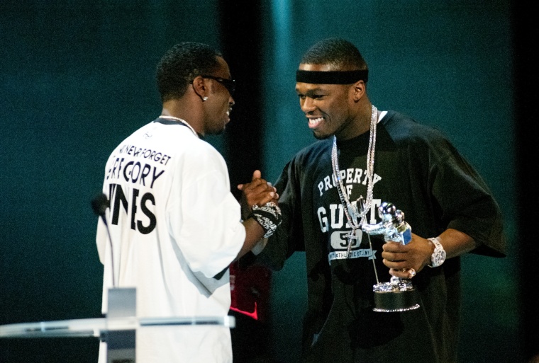 Diddy, left, and 50 Cent shake hands on stage