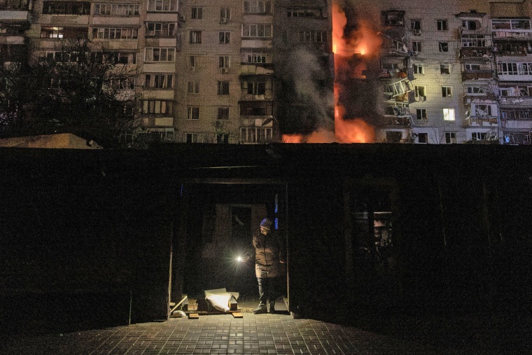 A local resident checks for damage next to a residential building on fire following a Russian drone attack on the city of Vyshhorod, in the Kyiv region, early on Nov. 30, 2025.