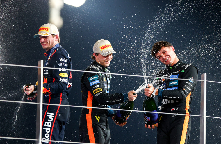 Lando Norris wins Formula 1 world championship in the final race of 2025 3 From left, Max Verstappen, Oscar Piastri, and Lando Norris pop champagne on a balcony outside