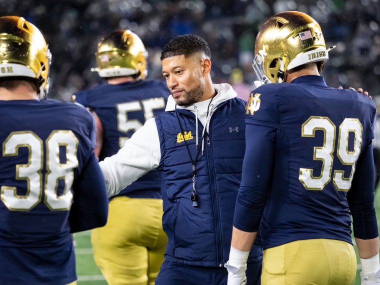 Marcus Freeman greets players on the football field