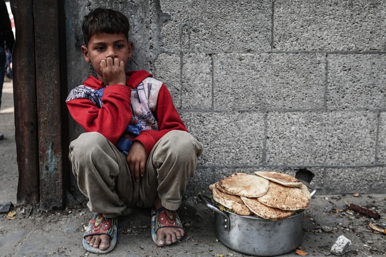 Displaced Palestinians receive food aid in Nuseirat Camp