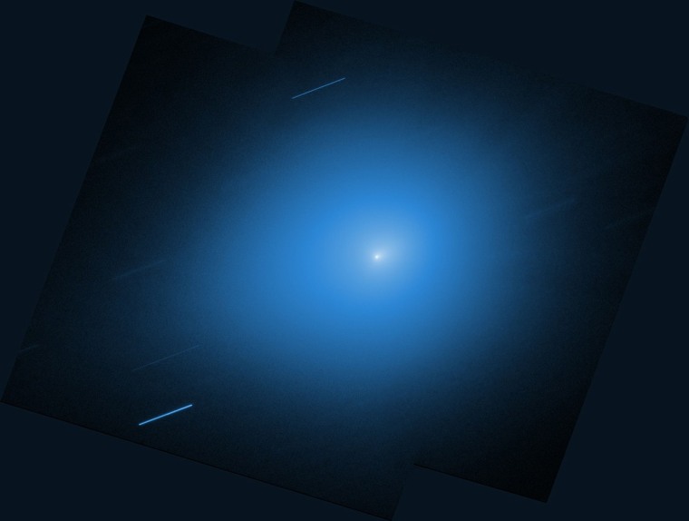 An interstellar comet is seen in the sky, two images superimposed