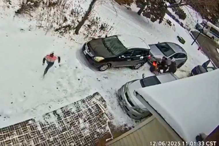 Uma mulher foge de agentes do ICE em uma garagem, com um homem detido ao fundo