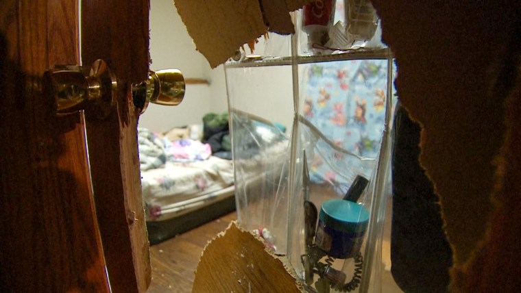 Um buraco na porta de madeira do quarto