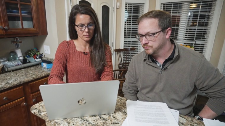 Maggie and Greyson Pope review insurance paperwork. The North Carolina Department of Insurance eventually overturned the denials they received.