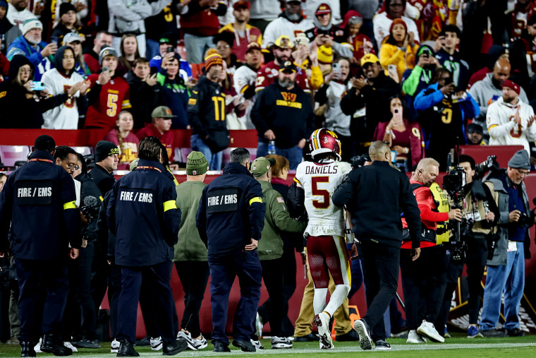 Jayden Daniels of the Washington Commanders is helped off the field after an injury during the second half of the NFL game against the Seattle Seahawks at Northwest Stadium on November 2 in Landover, Md.