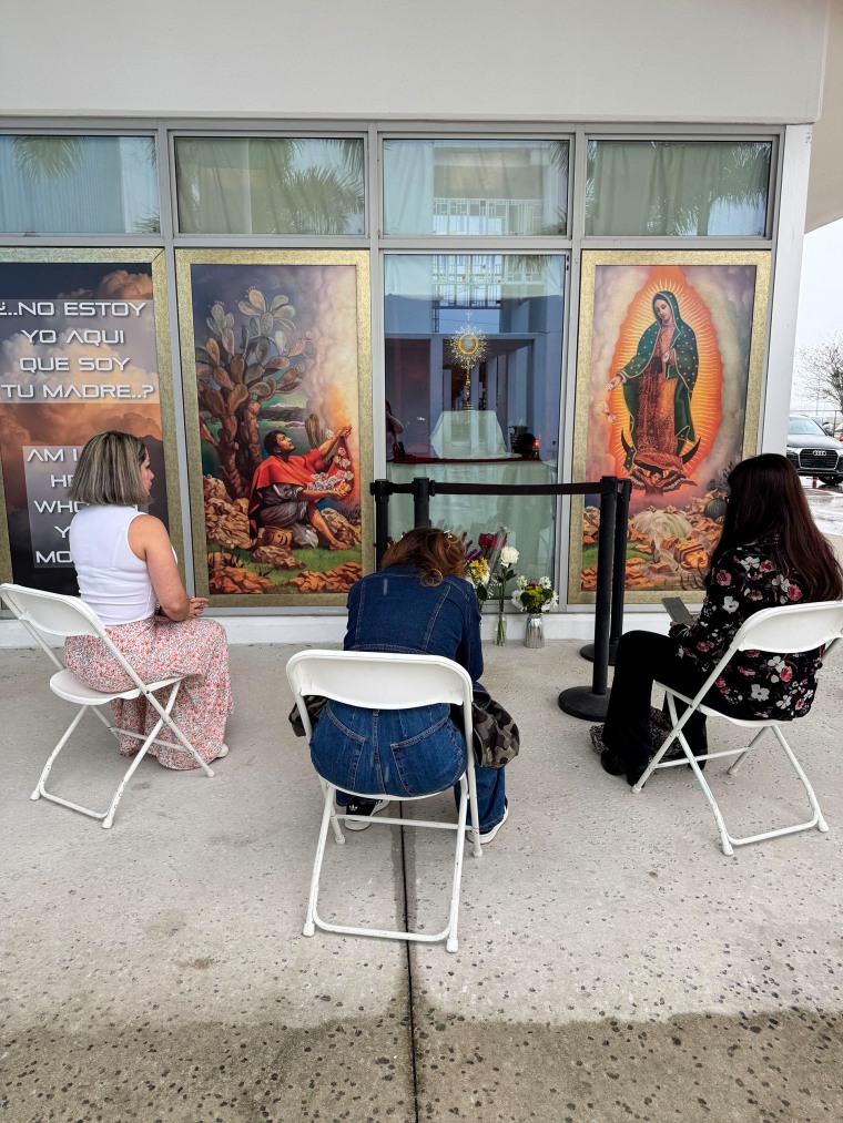 Maria Alejandra Barroso and two other women pray in front of the altar outside Our Lady of Guadalupe Catholic Church on Tuesday.