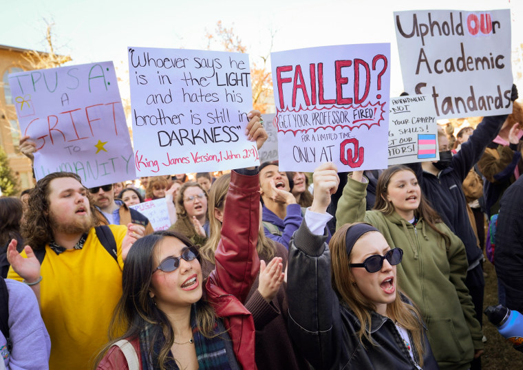 The crowd gathers at the administration building to chant and show their signs during a protest