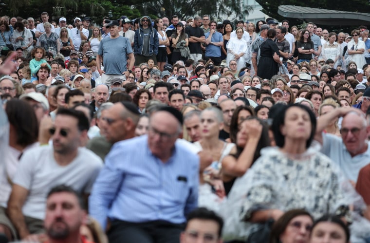 Pessoas em luto comparecem a um memorial pelas vítimas do tiroteio em Bondi Beach, em Sydney, em 21 de dezembro.