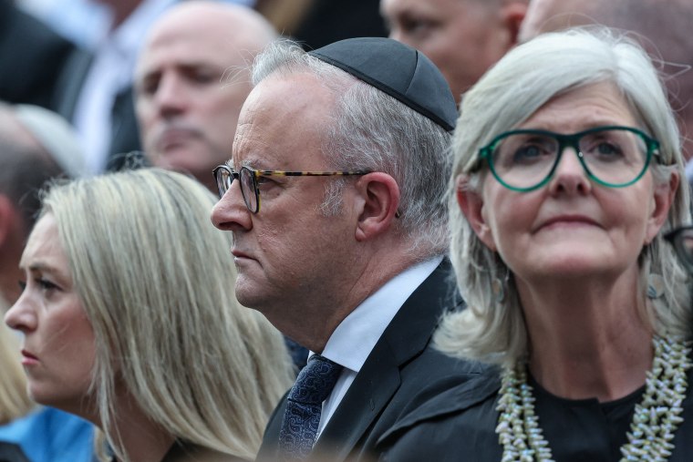 O primeiro-ministro australiano Anthony Albanese (C), sua esposa Jodie Haydon (L) e o governador-geral australiano Sam Mostyn (R) participam de um memorial às vítimas do tiroteio em Bondi Beach no domingo. 