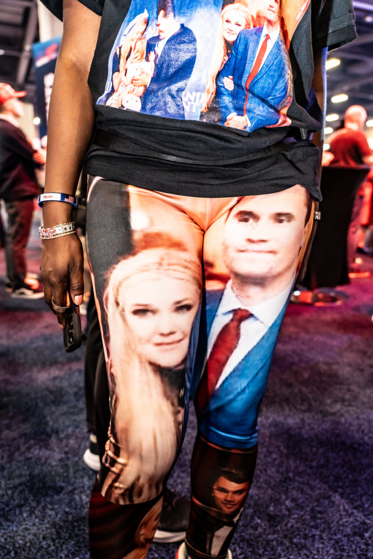 An event goer wears a top and pants with Erika and Charlie Kirk on them