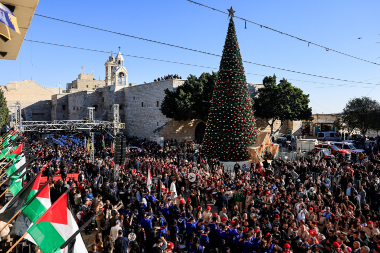 People gather next to the Christmas tree at Manger Square in Bethlehem