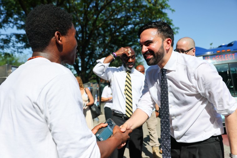 Zohran Mamdani apertando a mão de um jovem