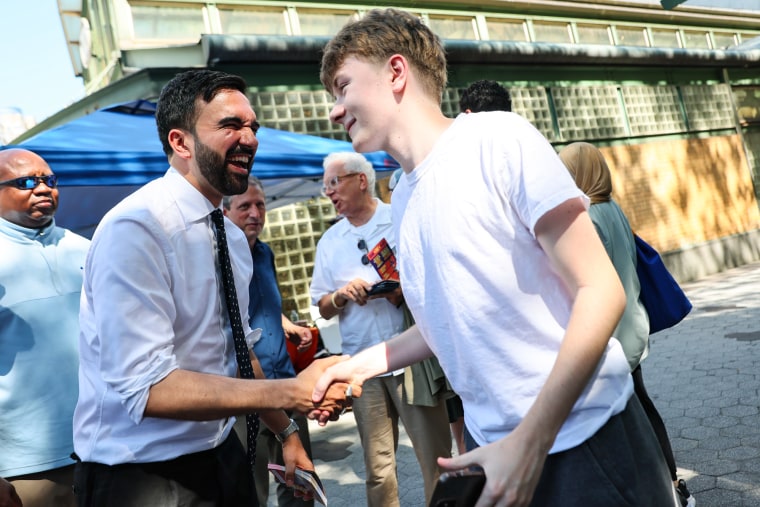 Zohran Mamdani apertando a mão de um jovem