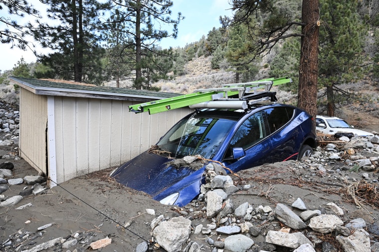 A car is buried in mud after a series of storms Thursday, Dec. 25, 2025, in Wrightwood, Calif. 