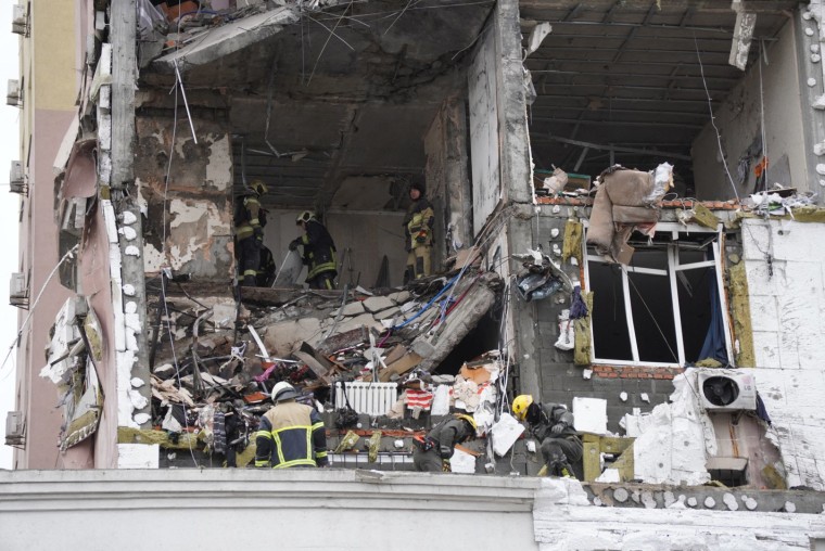 Rescatistas ucranianos revisan un edificio residencial dañado tras un ataque ruso en Kiev, el 27 de diciembre.