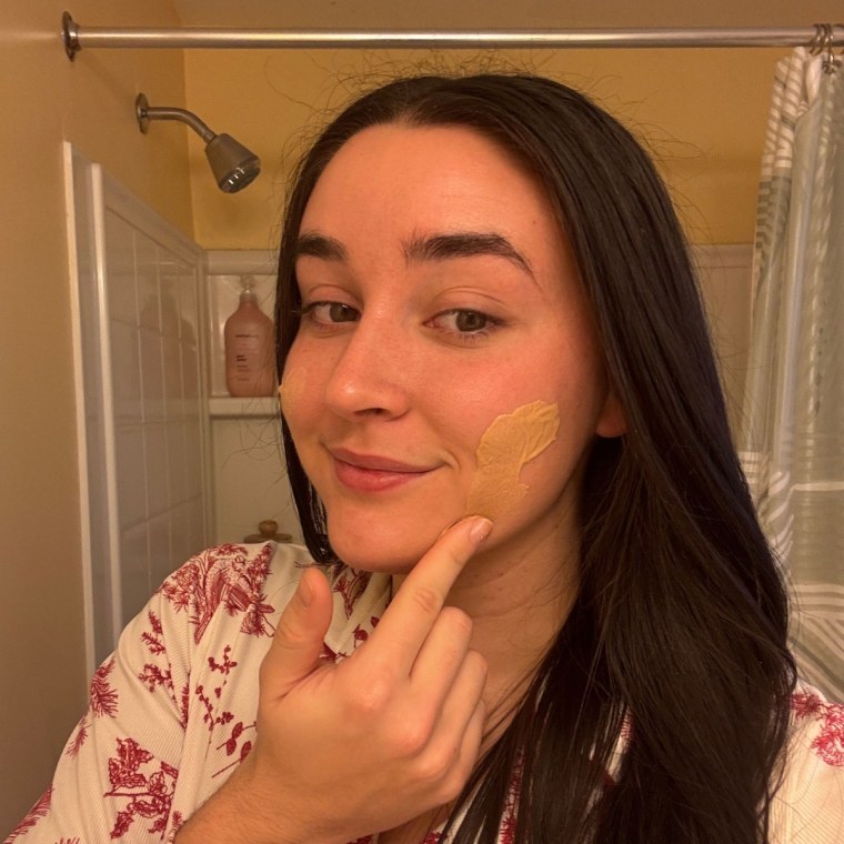 Woman applying tinted sunscreen on face