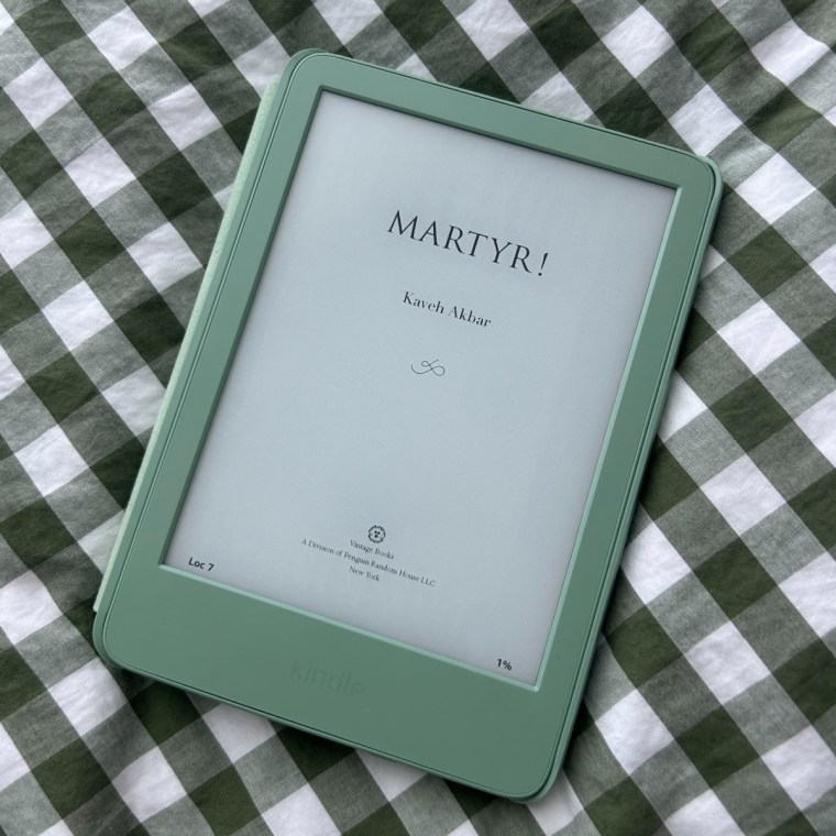 Green kindle on checkered bed sheet