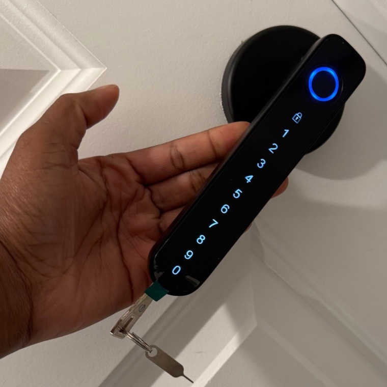 A hand behind a door handle with an LED touch button followed by numbers and a key at the end.