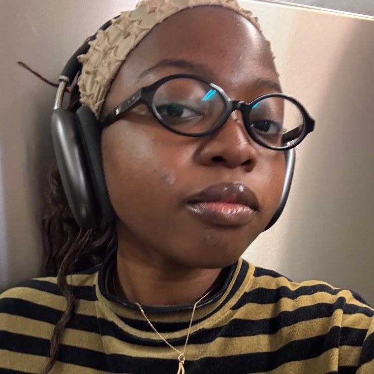 Alabi wearing the Good Molecules Pimple Patches with glasses, a headband and over-ear headphones.