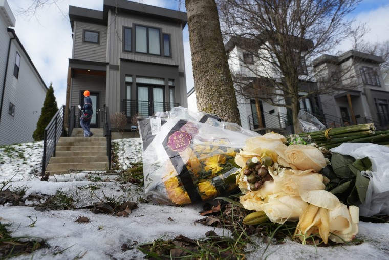 Flowers adorn the curb outside a home.