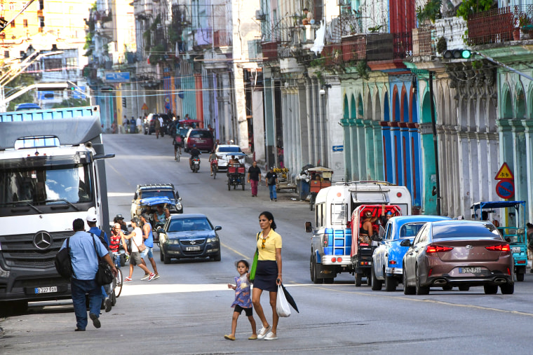 A woman with a girl passes a street in Havana