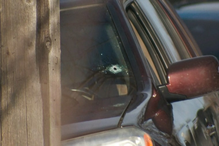 Um buraco de bala é visto no para-brisa de um carro