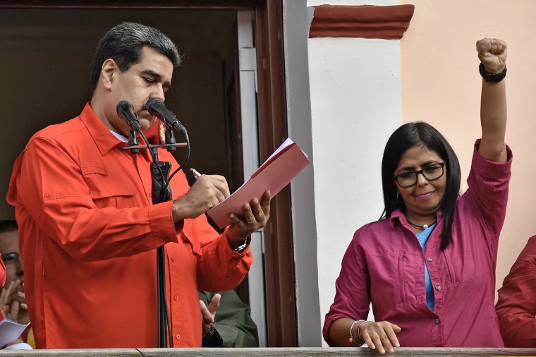 Vice President Delcy Rodriguez raises her fist as Venezuela's President Nicolas Maduro signs a document to break off diplomatic ties with the United States on Jan. 23, 2019. 