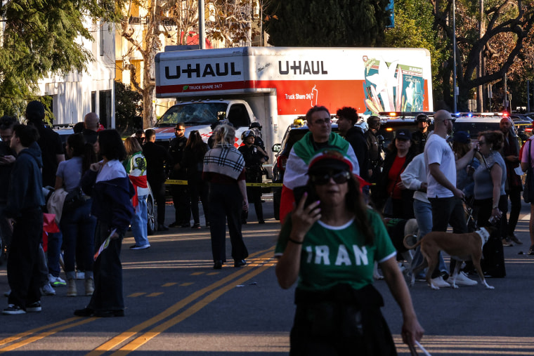 Image: People walk near a U-Haul truck that reportedly was driven into a crowd during an anti-Iranian regime rally