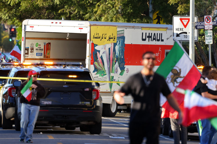 Image: People walk near a U-Haul truck that reportedly was driven into a crowd during an anti-Iranian regime rally