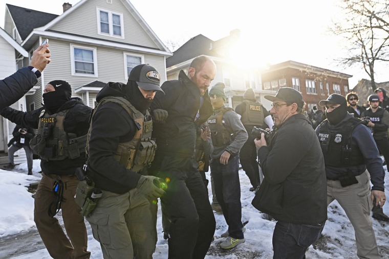 Un observador es detenido por agentes de ICE después de que arrestaron a dos personas en una residencia el 13 de enero de 2026 en Minneapolis.