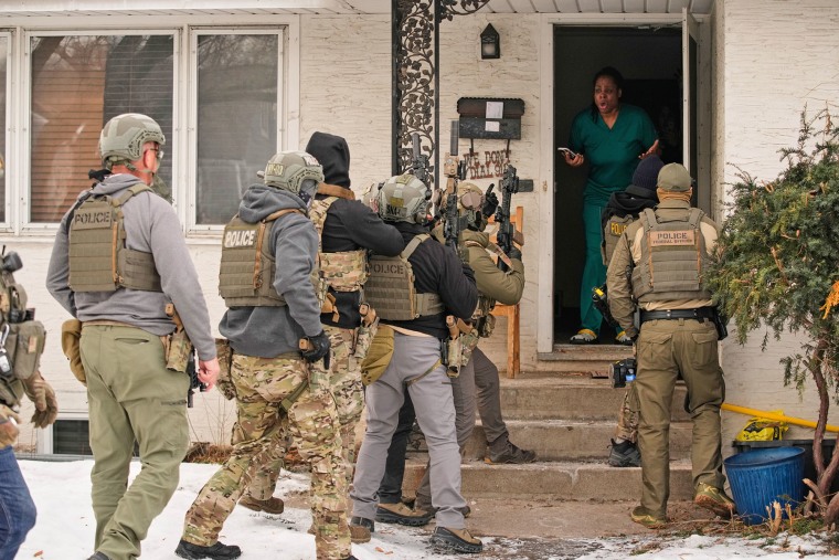 Teyana Gibson Brown, second from right, wife of Garrison Gibson, reacts after a federal immigration officer used a battering ram to break down a door before arresting Garrison Gibson, Sunday, Jan. 11, 2026, in Minneapolis. 