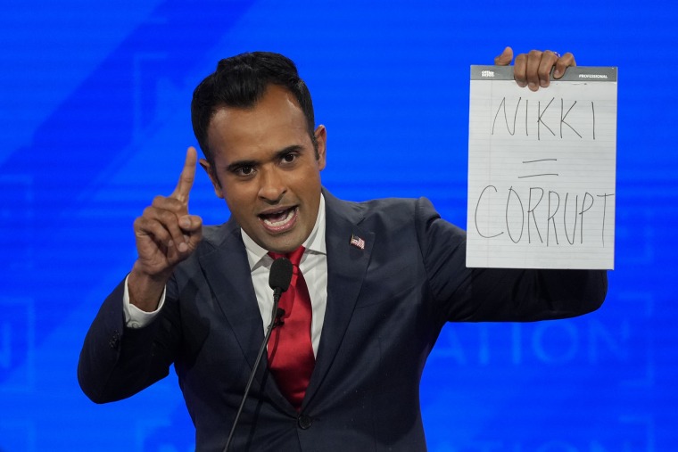 Then-Republican presidential candidate Vivek Ramaswamy holds up a pad of paper with a message referring to fellow candidate Nikki Haley