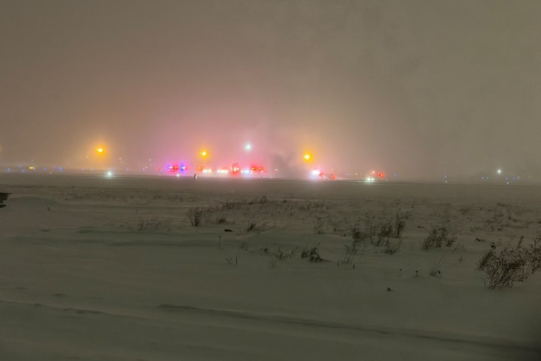 Lights are seen in the distance Sunday night following the crash of a private Bombardier Challenger 600 jet at Bangor International Airport in Maine.