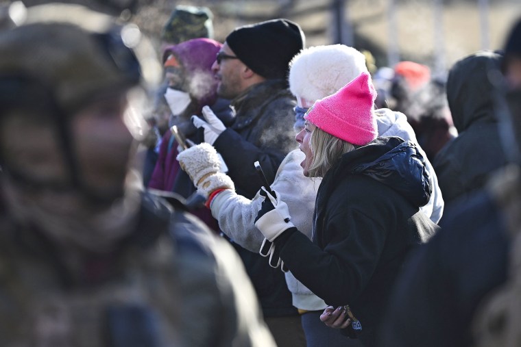 Protesters confront federal agents after a protestor was shot amid a scuffle to arrest him on January 24, 2026 in Minneapolis.