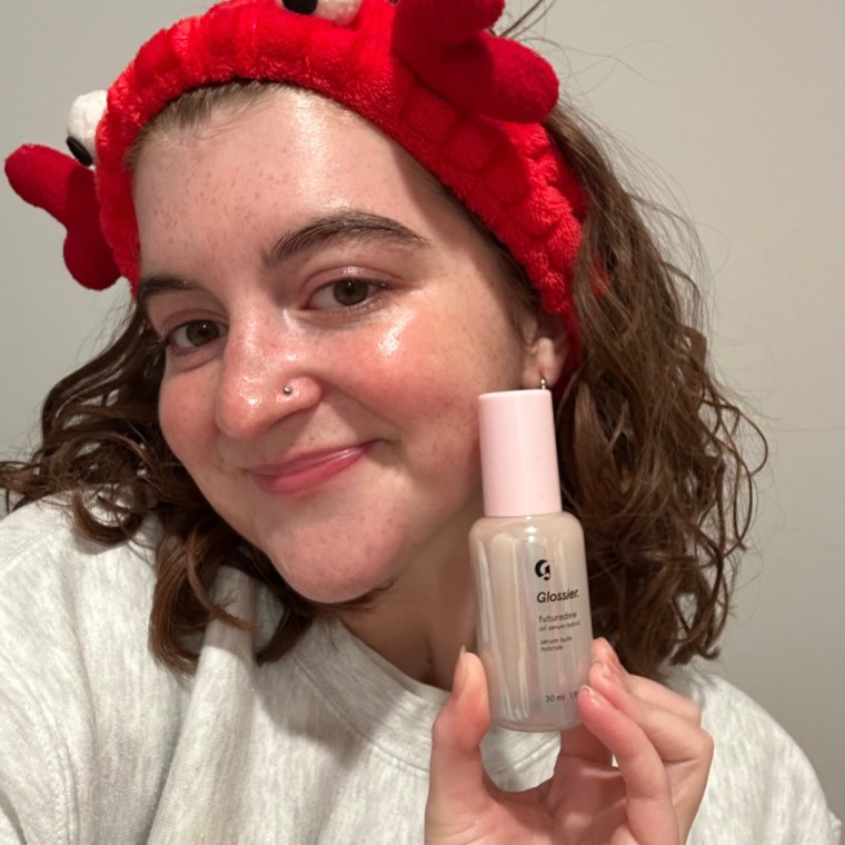 Woman holding Glossier Futuredew bottle.