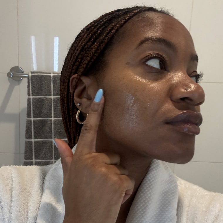 Woman applying serum to face
