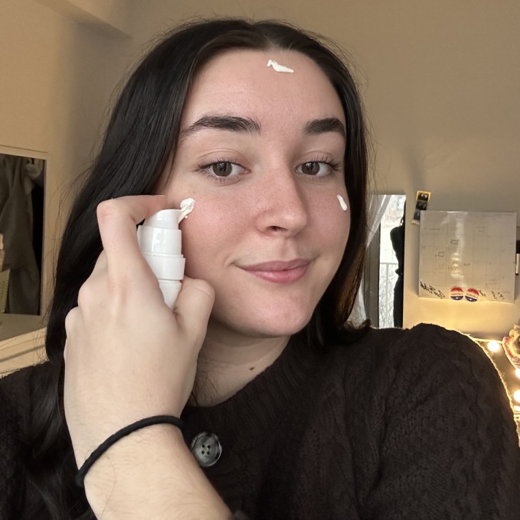 Woman applying sunscreen on face.