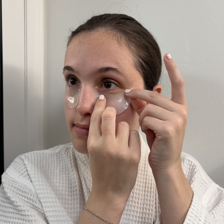 Woman applying eye patches on her under eyes