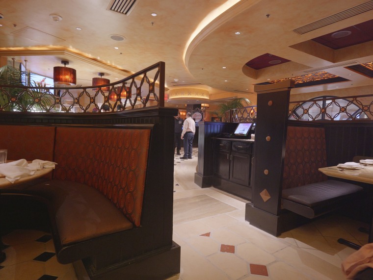 A Cheesecake Factory employee converses with another.