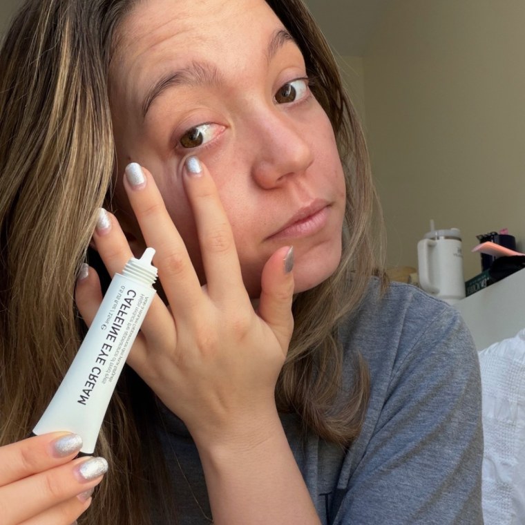 Woman applying eye cream.