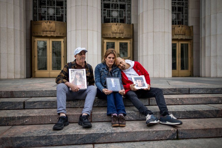 Three people picture frames while sitting on outside a Superior Court.
