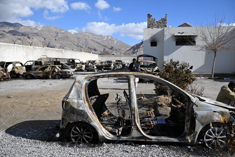 A man stands beside burned vehicles in a torched police station on the outskirts of Quetta on Sunday.