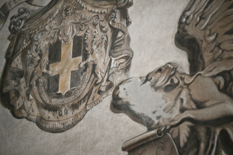 Grey paint covering the face of an angel painting