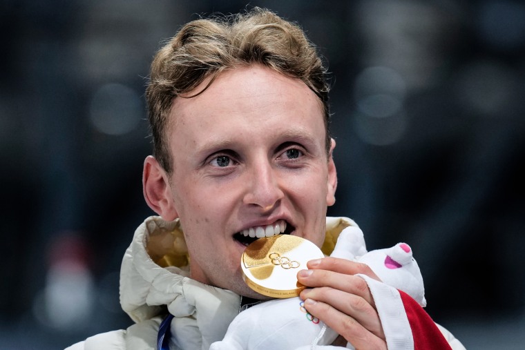 Sander Eitrem bites a gold Olympic medallion