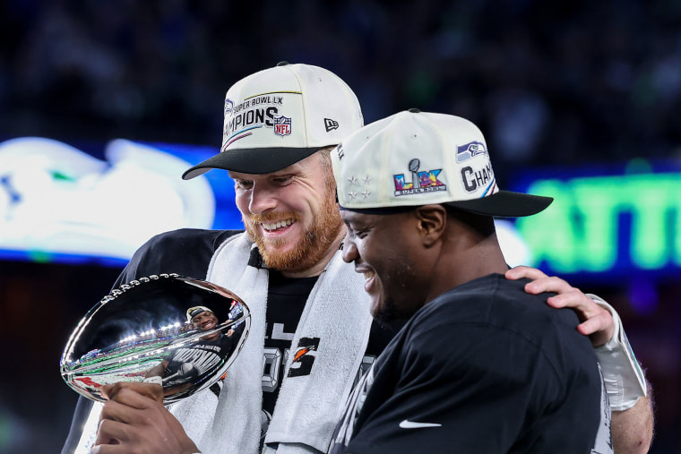 Sam Darnold #14 and Kenneth Walker III #9 of the Seattle Seahawks celebrate with the Vince Lombardi Trophy