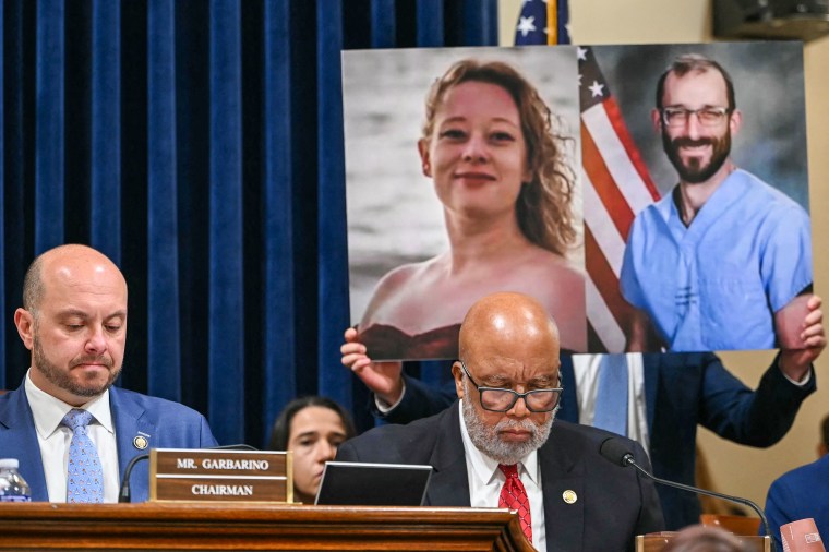 Pictures of Renee Good and Alex Pretti, both killed by federal immigration agents in Minneapolis, are displayed behind committee ranking member US Representative Bennie Thompson
