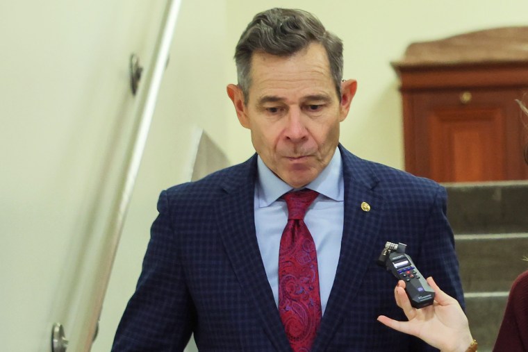 U.S. Sen. John Curtis walks down the stairs of the US Capitol as a reporter asks him questions.