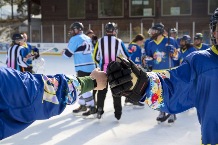 Hockey player fistbumping on the ice.