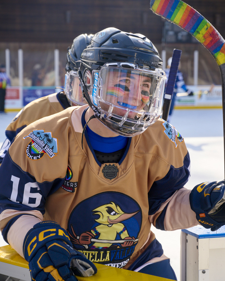 Joey Gale holding a rainbow hockey stick